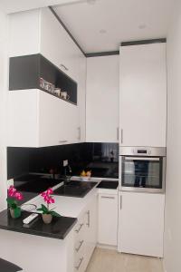 a white kitchen with black counters and white cabinets at Mariner 602 in Sutomore