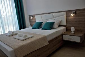 a bedroom with a large white bed with blue pillows at Mariner 602 in Sutomore