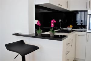a kitchen with a counter with vases with flowers on it at Mariner 602 in Sutomore +31 photos