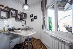 uma cozinha com uma mesa e uma janela em Urban Chic em Novi Sad