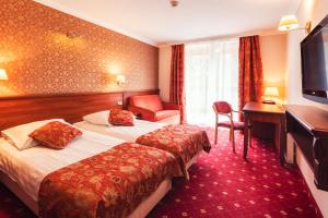 um quarto de hotel com duas camas e uma secretária em Hotel Albatros em Serwy