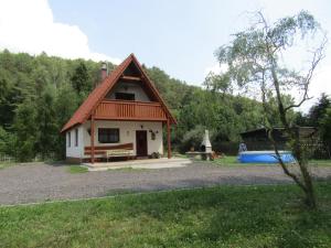 una pequeña casa con un banco y un parque infantil en Rekreacni Dum Brdy en Ohrazenice