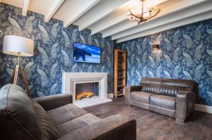 a living room with a couch and a fireplace at High Oaks Grange - Cottages in Pickering
