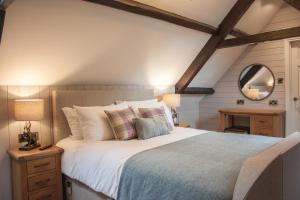 a bedroom with a large bed and a mirror at High Oaks Grange - Cottages in Pickering