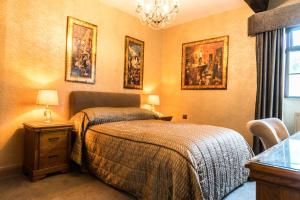 a bedroom with a bed and paintings on the wall at The Mews Hotel in Wakefield
