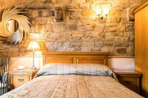 sypialnia z łóżkiem i kamienną ścianą w obiekcie The Mews Hotel w mieście Wakefield