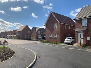 eine Straße mit Häusern und einem weißen Auto auf der Straße in der Unterkunft Home Crowd Luxury Apartments- Auckley House in Doncaster