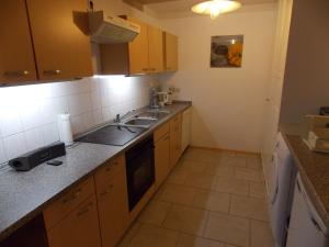 eine kleine Küche mit Holzschränken und einer Spüle in der Unterkunft Ferienwohnung Welz in Schönburg