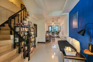 a living room with a staircase and a blue wall at 台南安平作夥憩海邊 Taiowan One Piece Anping House in Anping