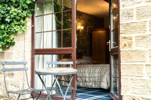 a room with a bed and a chair and a window at The Mews Hotel in Wakefield