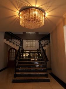 a chandelier hangs above a staircase in a building at Hotel Cristal Rio Claro in Rio Claro