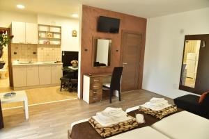 ein Wohnzimmer mit einem Sofa und einem Tisch sowie eine Küche in der Unterkunft Apartmani Centar Kumanovo in Kumanovo