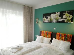 ein Schlafzimmer mit einem großen Bett mit weißer Bettwäsche in der Unterkunft Hotel & Gasthaus Zum Domkreuger in Walsrode