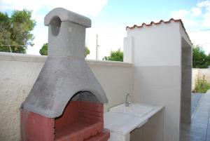 a kitchen with a pizza oven on the side of a building at Villa Cohiba - 700m dal mare in Pulsano