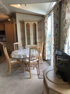a dining room with a table and chairs and a window at Countryside views from a luxury mobile home near Perranporth in Perranporth