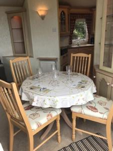 a table with two chairs and a table with a table cloth at Countryside views from a luxury mobile home near Perranporth in Perranporth