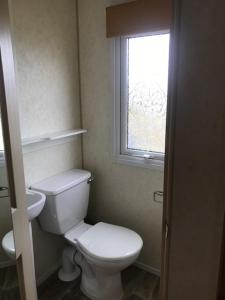 a bathroom with a white toilet and a window at Countryside views from a luxury mobile home near Perranporth in Perranporth