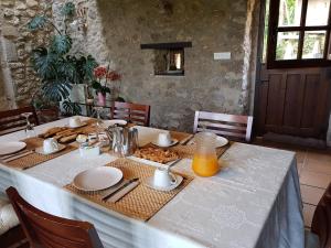 una mesa con mantel blanco y zumo de naranja. en Amaicha Hotel Rural en Ribadesella