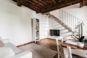 uma sala de estar com um sofá branco e uma mesa em Residenza i Pini em Lucca