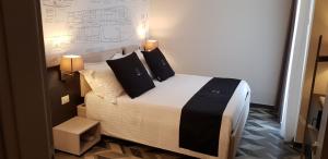 1 dormitorio con 1 cama con 2 almohadas negras en Riva 33, en Porto Cesareo