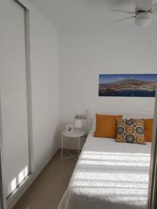 een witte slaapkamer met een bed en een raam bij Oliva Home in Los Cristianos