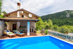 a villa with a swimming pool and a house at House Pavincic in Lovran