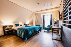 um quarto com uma cama, uma mesa e cadeiras em Hotel Hoogeveen em Hoogeveen
