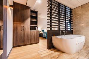 een badkamer met een groot bad in een kamer bij Hotel Hoogeveen in Hoogeveen