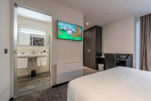 a hotel room with a television on the wall at Hotel Monarc in Ostend