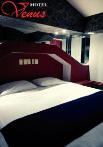 a bedroom with a large bed with a red headboard at Auto Hotel Venus in Xalapa