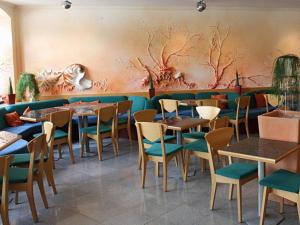 a restaurant with tables and chairs in a room at Stadtcafé Hotel garni in Hammelburg