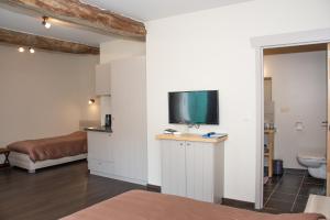 een kamer met een bed en een tv aan de muur bij B&B De Oude Winning in Riemst