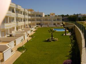 an apartment complex with a lawn in front of a building at Jardim Paraiso Apartments in Albufeira