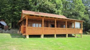 Cabaña de madera grande con terraza en el césped en Molfar House, en Kosiv