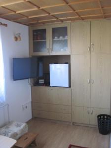 a kitchen with wooden cabinets and a flat screen tv at edelweiss in Radovljica