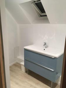 ein Waschbecken mit blauer Kommode im Zimmer in der Unterkunft Gite Bord de Mer 80 m2 in Bernières-sur-Mer