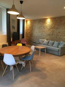 Gite Bord de Mer 80 m2 في Bernières-sur-Mer: غرفة معيشة مع أريكة وطاولة وكراسي
