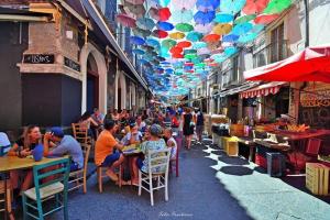 un groupe de personnes assises à des tables dans une ruelle dans l'établissement Casa Gisira, à Catane