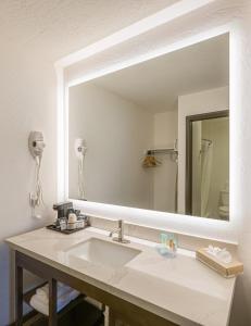 a bathroom with a sink and a large mirror at Lux Verde Hotel in Cottonwood