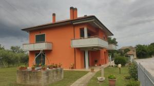 a orange house with two balconies on the side of it at Da Dany in Monte San Vito