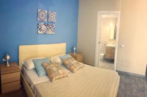 ナポリにあるEmyJo Central B&Bの青い壁のベッドルーム1室(ベッド1台付)
