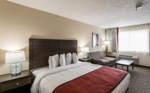a hotel room with a large bed and a couch at Lux Verde Hotel in Cottonwood +36 photos