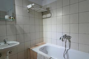 y baño con bañera y lavamanos. en Pravi Hotel, en Eleftheroúpolis