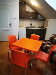 a kitchen with a table and orange chairs in a room at CENTRAL PARK SOKOBANJA in Soko Banja