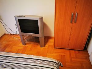 a television sitting on a wooden floor next to a cabinet at CENTRAL PARK SOKOBANJA in Soko Banja