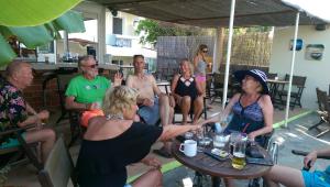 a group of people sitting around a table at Manine Apartments in Kos