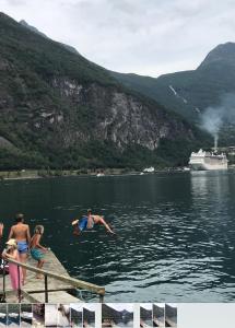 a person jumping off a dock into a body of water at Solhaug Fjordcamping in Geiranger
