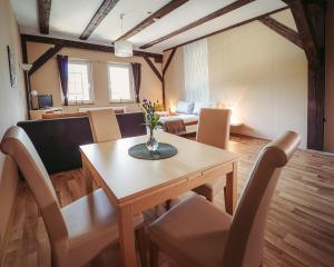 Una sala de estar con una mesa y sillas de madera. en Ferienwohnungen an der Wassermühle, en Quedlinburg 25 fotos más