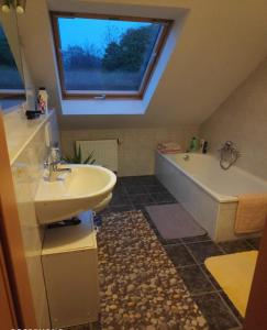 baño con lavabo, bañera y ventana en Inseldorf Wardt, en Xanten