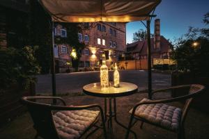 una mesa con 2 sillas y una mesa con sombrilla en Ferienwohnungen an der Wassermühle, en Quedlinburg